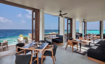 a dining area with tables and chairs set up for a meal , overlooking the ocean at Heritance Aarah-Premium All Inclusive