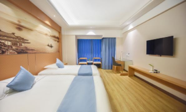 A spacious room on the second floor of the hotel with double beds and a connected sitting area at Huachen San Siro Hotel