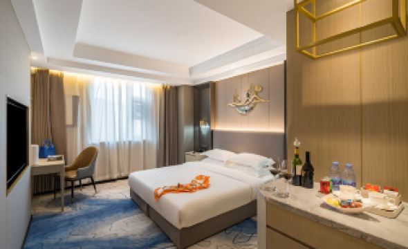 The middle room features a spacious bed with an adjoining sitting area and a table at VOYAGE INTERNATIONAL HOTEL (Capital Airport New National Exhibition Store)