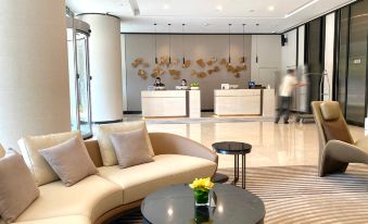 The hotel features a contemporary lobby with spacious windows, comfortable couches, and tables arranged in the center at Riverdale Residence Xintiandi Shanghai