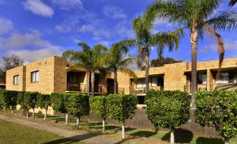 a large brick house surrounded by trees and bushes , located in a grassy area at Ryde Inn