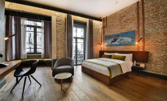 a spacious bedroom with hardwood floors , a large bed , and a tv mounted on the wall at Hotel The Public - Special Category