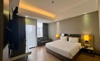 a modern hotel room with a large bed , couch , and tv , all arranged in a clean and well - organized environment at Livingston Hotel