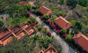 aerial view of a red - roofed house surrounded by lush greenery , with flowers blooming in the yard at Victoria Nui Sam Lodge