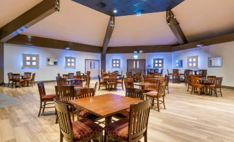 a large dining room with wooden tables and chairs arranged for a group of people at Pine Lake Resort