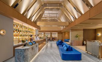 The lobby features a spacious wood-paneled ceiling and multiple seating areas on the side at Crystal Orange Shenzhen Nanshan Science and Technology Park