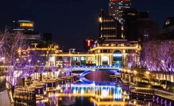 A city illuminated at night with buildings on either side at FX Hotel (Beijing Yansha)