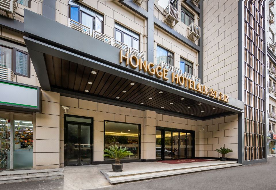 The main entrance of a hotel is depicted in the photo, showing an exterior view and a sign above it at Hongge Apartment Hotel