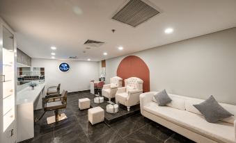 a modern , white - themed waiting area with comfortable seating and a bar area in the background at Seashells Phu Quoc Hotel & Spa