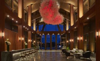 The lobby is illuminated by overhead lighting and features chairs and tables at The Westin Yilan Resort