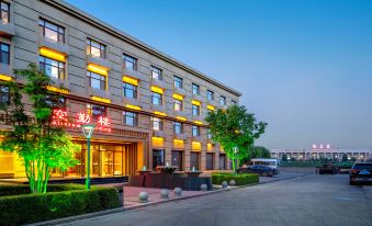 At night, there is an illuminated hotel in front of the viewer when looking at the exterior view from across the street at Konggang Hotel (Harbin Airport International Terminal)