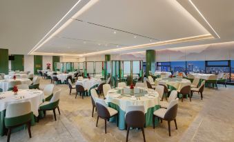 a large dining room filled with round tables and chairs , ready for guests to enjoy a meal at Guangzhou Hotel（Canton Fair Free Shuttle Bus）