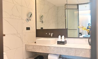 a bathtub with a showerhead and a toilet at Fuzhou Oriental Yanzhuo Hotel