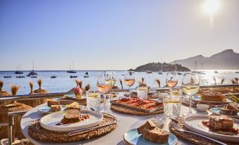 a dining table set with a variety of food and drinks , including wine glasses , plates , and utensils at Universal Hotel Aquamarin