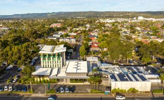 aerial view of a city with a tall building in the center , surrounded by trees and buildings at Marion Hotel