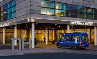 "a blue van is parked in front of a building with the sign "" nh hotels ""." at NH Amsterdam Schiphol Airport