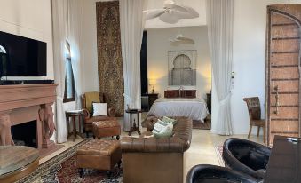 a modern living room with white walls , wooden furniture , and large windows , featuring a brown leather couch , coffee table , and other pieces of at Jodhai Bai Retreat