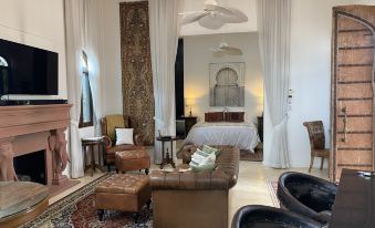 a modern living room with white walls , wooden furniture , and large windows , featuring a brown leather couch , coffee table , and other pieces of at Jodha Bai Retreat