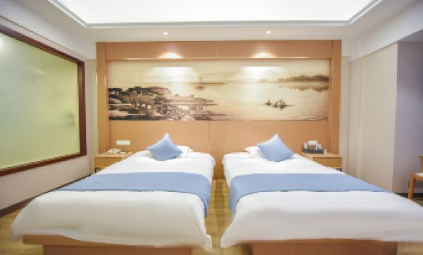 The spacious bedroom features double beds and offers a refreshing view of the beachfront living area at Huachen San Siro Hotel