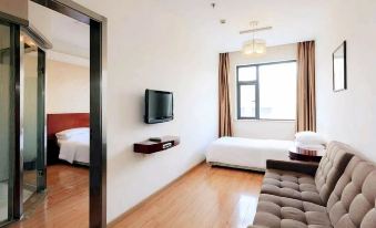 There is a small room with a bed, television, and a large window located next to the living area at Motai Hotel (Shanghai Hongqiao International Exhibition Center Jiuxing)
