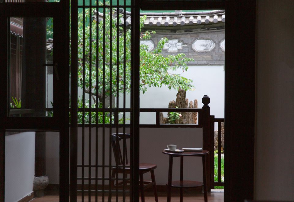 [돌담과 나무가 어우러진 밋 유 인 리장의 아늑한 마당]