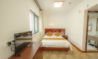 The open concept room features a double bed, desk, and large window in the center at Guangmingding Hotel