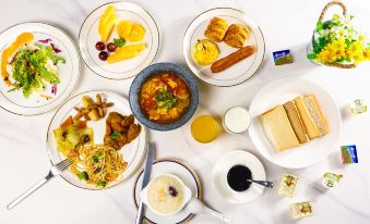 A table is set with plates and bowls filled to the brim with a complete meal, including soup at Hongge Apartment Hotel