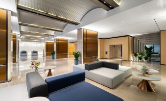 The large room is furnished with modern furniture and features an atrium that leads to the lobby at Rezen Select Hotel Guangzhou Baiyun International Airport (Terminal T2 Branch)