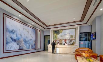 a modern hotel lobby with white walls , blue ceiling , and large paintings on the walls at Vienna Hotel
