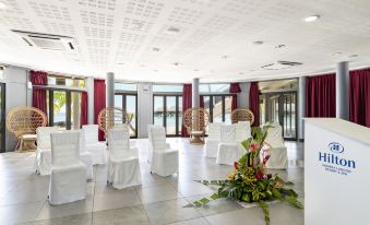 a large room with white chairs and a vase of flowers is decorated for an event at Hilton Moorea Lagoon Resort and Spa