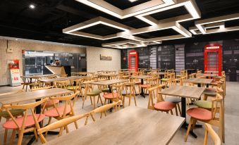 a large dining room with wooden tables and chairs , and a red phone booth in the background at Le Room Hotel Taoyuan