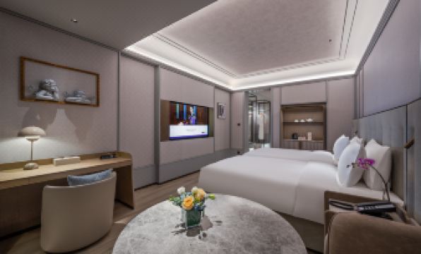 The middle room features a large bed with a table and chairs next to it, creating an elegant setting at Grand Mercure Hangzhou Zijingang