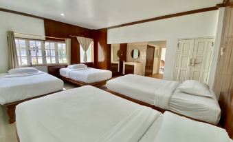 a hotel room with three beds , two of which are made up with white sheets at Funwan Hotel