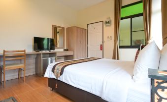 a clean and well - organized bedroom with a white bed , a television , and a dresser at Baan Kieng Tawan