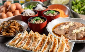 a table is filled with various types of food , including dumplings and bowls of noodles at HOTEL MYSTAYS Utsunomiya