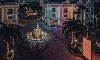 an aerial view of a city at night , featuring a fountain in the center surrounded by buildings and illuminated lights at Ramada Suites by Wyndham Solo