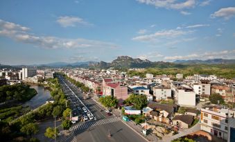 an aerial view of a city with a large road , buildings , and mountains in the background at Diamond Hotel (Liancheng Guanzhishan Airport)