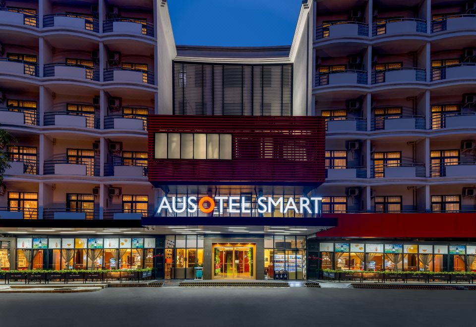 The front view of the hotel and restaurant at night is enhanced by a large sign on top at Ausotel Smart Guangzhou Baiyun International Airport Terminal 1