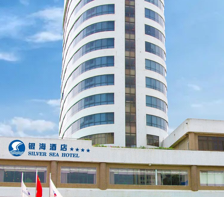 "a tall white building with a curved facade and the words "" golden silk hotel "" written on it" at Silver Sea Hotel