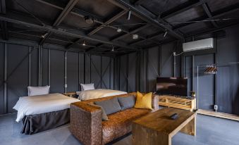 a modern living room with black walls , wooden floors , and large windows , featuring a couch , coffee table , and tv at The Retreat