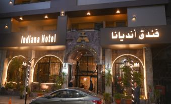 "a hotel entrance with a sign that reads "" indiana hotel "" and a man standing outside" at Indiana Hotel