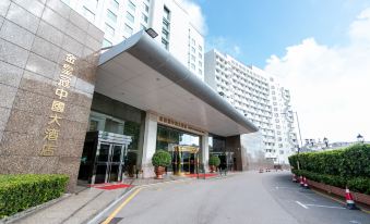 The entrance to a hotel in an urban setting features large glass and steel doors on both sides at Golden Crown China Hotel