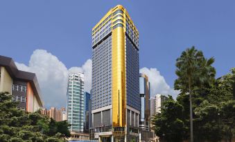 A large office tower surrounded by other buildings at Regal Hongkong Hotel