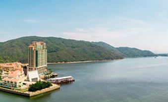 There is a large body of water with mountains in the background, surrounded by hills on either side at Auberge Discovery Bay Hong Kong