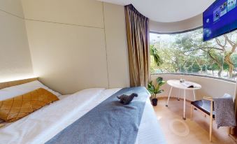 The modern-style bedroom features large windows that provide an airy view from the bed at Coliwoo Orchard - Co-Living Serviced Apartments