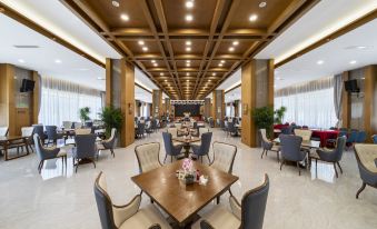 a large , modern dining room with wooden tables and chairs arranged for a group of people to enjoy a meal together at Tibet Hotel