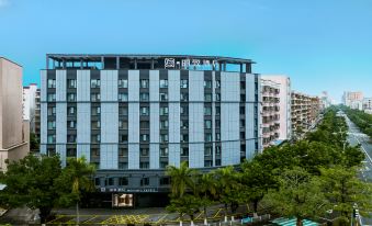 A large building with an exterior view is situated on one side, facing the hotel at Mehood Lestie Hotel (Maoming High-speed Railway Station)