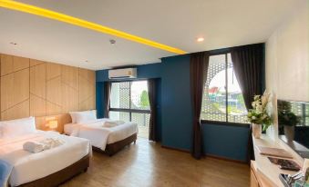 a hotel room with two beds , a window , and a balcony view , all lit by yellow lights at Hotel Fuse Rayong