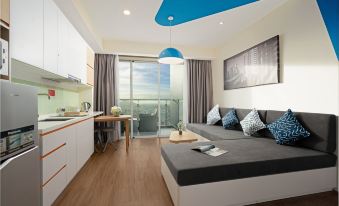 a modern apartment with a bed , kitchen area , and sliding glass door leading to a balcony at TUI BLUE Nha Trang