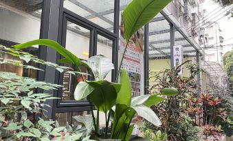 includes an office space that is filled with plants and flowers, creating a serene and natural environment at Yue City Youth Apartment